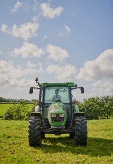 Every farmer needs one. Full length shot of a green tractor on an open piece of farmland